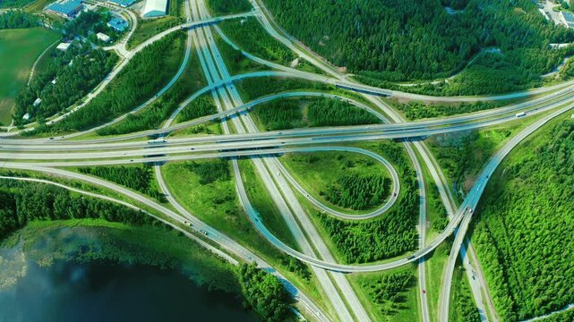 Aerial View of Complex Highway Interchange Surrounded by Lush Greenery and Water Bodies in Finland