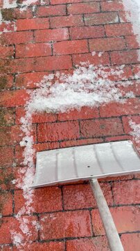 Video zeigt die Auswirkungen von Eisregen im Winter: Mit einem Schneeschieber wird versucht, eine vereiste Oberfl&auml;che zu r&auml;umen, doch die fest gefrorene Eisschicht l&auml;sst sich kaum entfernen. Typische 