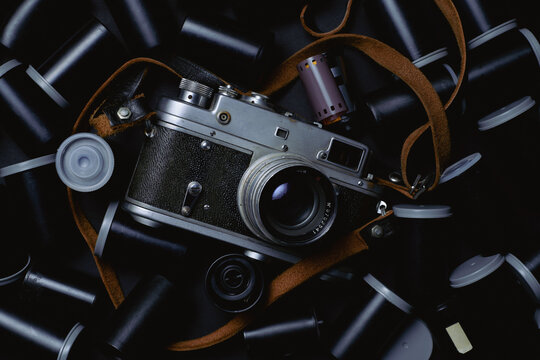 Vintage Film Camera Surrounded by Film Canisters