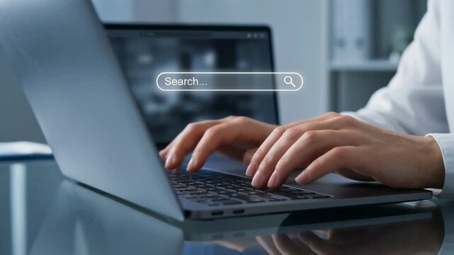 Person typing on laptop keyboard with search bar in modern workspace technology concept