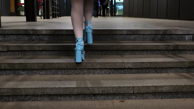Woman in lolita style outfit wearing high heels climbing stairs