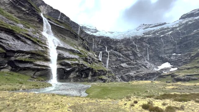 Waterfall from cliffy mountain wall, Earnslaw Glacier, New Zealand pristine nature. Outdoors