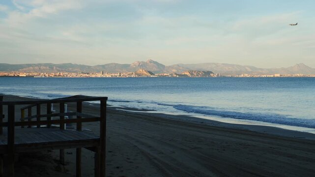 Airplane landing over the sea, with the city of Alicante in the background, in slow motion x0,5. Spain.
