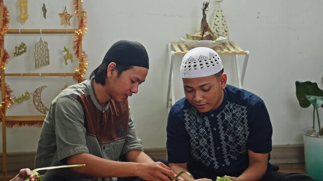 Happy Muslims friends making Ketupat rice cakes while chatting and sharing high-five 
