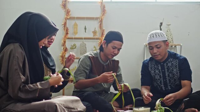 Happy Muslim friends cheering and celebrating after successfully weaving Ketupat casing