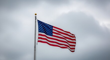 Obraz premium American flag waving in the wind on a cloudy day
