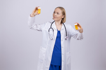 Doctor in white coat holding pill bottle and tablet