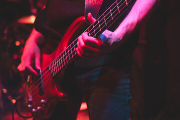 Zbliżenie na dłonie mężczyzny grającego na gitarze w klubie