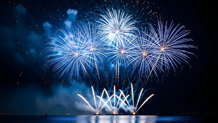 Vibrant blue fireworks exploding over water at night