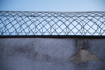 Mur więzienia z drutem kolczastym © Katarzyna