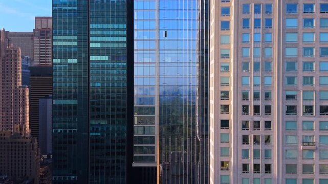 Aerial drone close up of modern glass skyscrapers in Midtown Manhattan, New York City, New York showing dense urban architecture, reflections and vertical city growth. USA.