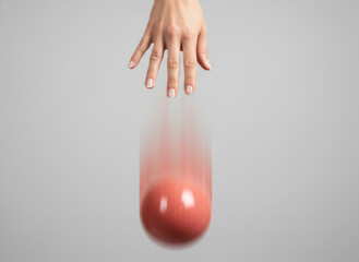 Hand dropping a red ball with motion blur, symbolizing gravity, action, or the release of control