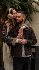 Young couple sharing a tender kiss outdoors during a cold winter day, embracing warmly