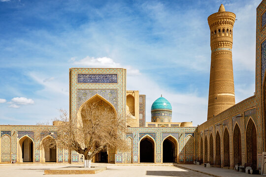 Poi Kalyan complex in Bukhara, Uzbekistan, with Kalyan Mosque, Mir-i-Arab Madrasa and iconic minaret under blue sky