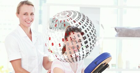 Massaging therapist in white treating pink-top client seated on blue pad in spa with binary sphere