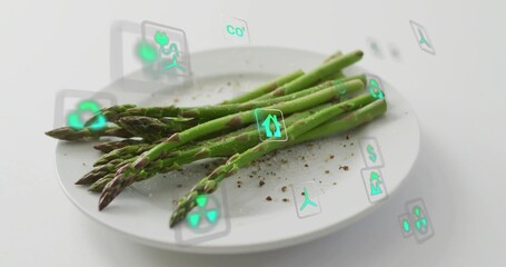 Naklejka premium Showing bundle green asparagus spears diagonal on white plate in studio with pepper and AR icons