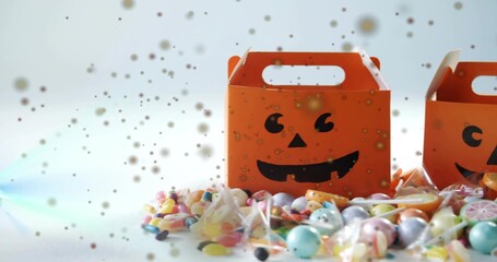 Displaying single orange jack-o-lantern box sitting right of center on white tabletop, with candies © vectorfusionart