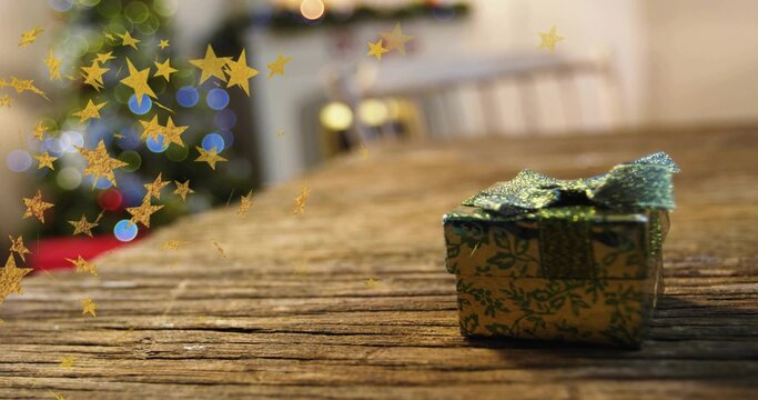 Sitting gift box wrapped in green gold paper with glittery ribbon near evergreen tree, copy space