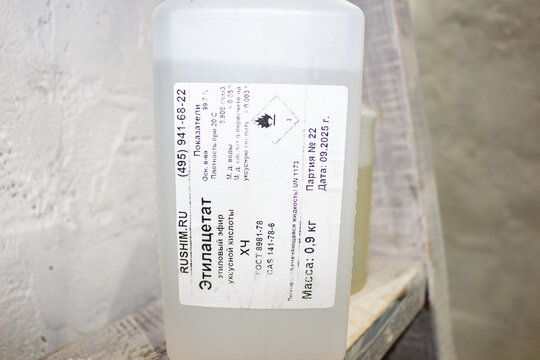 Close-up on a plastic container label detailing chemical information for Ethyl Acetate, a flammable liquid ingredient: Russia - November 18, 2025