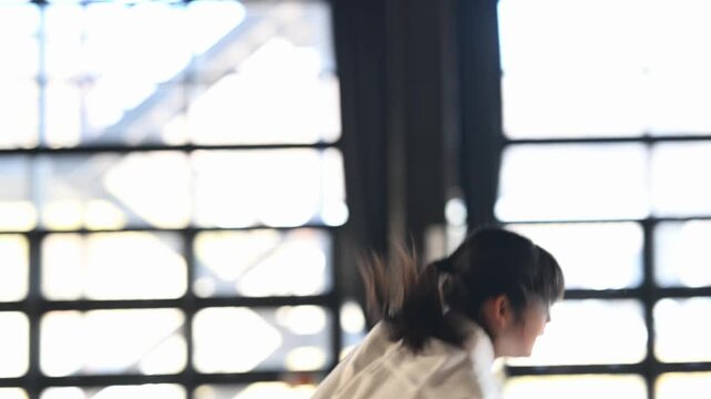 道場で気合の掛け声を出す空手着の女の子の横顔