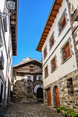 Strolling through Isaba in Roncal valley, Pyrenees, Navarre in Spain with brownish tiled roofs of residential buildings