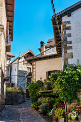 Strolling through Isaba in Roncal valley, Pyrenees, Navarre in Spain with brownish tiled roofs of residential buildings