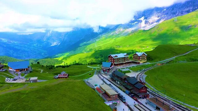 A peaceful Swiss alpine village in green meadows with mountains and blue sky in summer HD video.