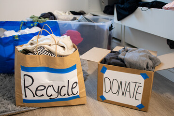 Two paper bags full with clothes for recycling and donation standing on the floor of a wardrobe  © TatjanaMeininger
