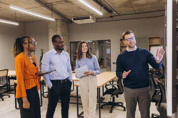 Fototapeta premium Diverse professionals collaborating during business meeting, strategizing in modern open plan office with collaborative workspace layout