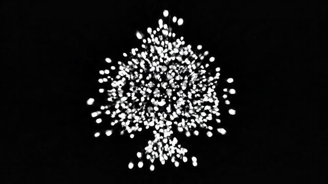 Illuminated spade shape formed by many small white spheres against dark background