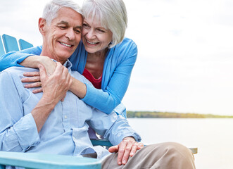 Obraz premium Smile, hug and senior couple outdoor on bench with bonding, love and care together on holiday. Happy, space and elderly woman embracing man for marriage connection on summer vacation or weekend trip.