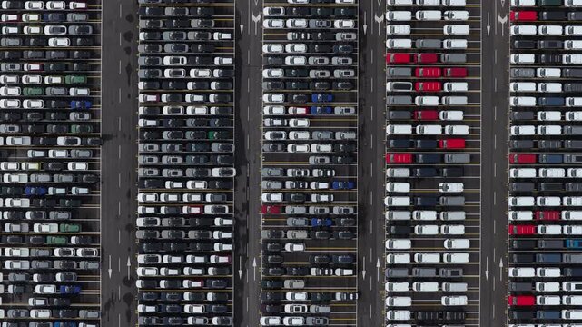 Aerial view of a grid of parked cars, in organized rows with roads in between, creating a pattern of dark and light tones, Trieste, Friuli-Venezia Giulia, Italy.