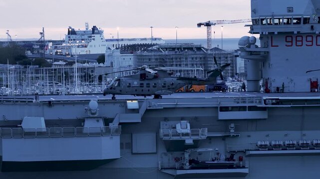Aerial view of a helicopter on the deck of a ship, with a city skyline and cranes visible in the background, Trieste, Friuli-Venezia Giulia, Italy.