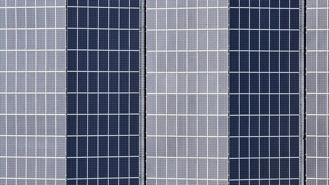 Aerial view of orderly rows of solar panels, creating a striking pattern of dark and light rectangles, harnessing the sun's energy, Trieste, Friuli-Venezia Giulia, Italy.