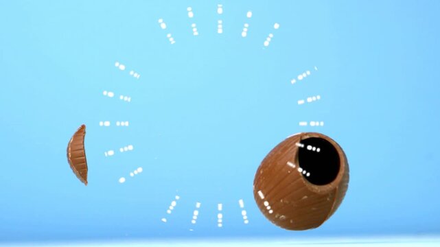 Milk chocolate egg rotating, splitting as dotted ring activating, revealing hollow ridged halves