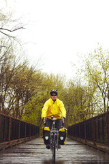 Obraz premium Bridge, exercise and man on bicycle in winter for fitness, active hobby and training outdoor. Sports, park and person on bike for cycling, workout and endurance for wellness, practice and health