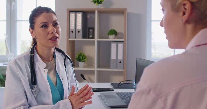 Medical consultation, female doctor wearing stethoscope, speaking with patient in professional med office, informative help and supportive talk, communication and guiding in medical discussion