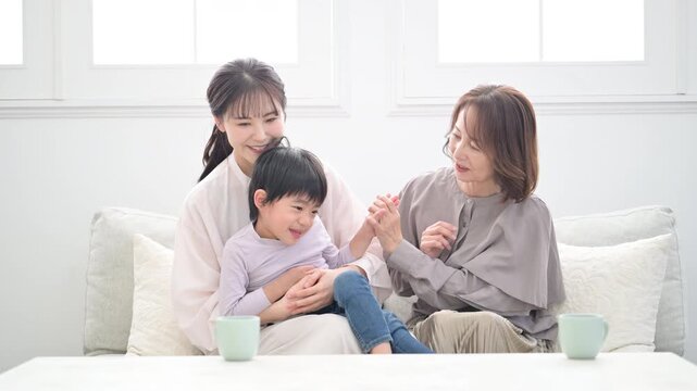 祖母と母と子どもが笑顔で抱き合う三世代家族、親子の幸せな動画