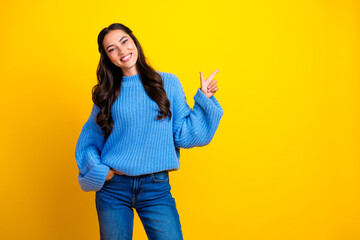 Young mixed race woman in blue sweater smiling pose against bright yellow background suitable for...