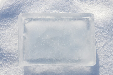 Ice block in the light blue tones surrounded with crushed ice on white background.