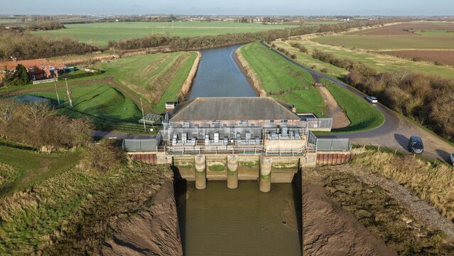 Aerial view of the Hobhole Pumping Station, a confluence of water and land under a serene sky, Hobhole pumping station, Boston, United Kingdom.
