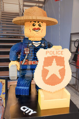 Fototapeta premium 1 December 2025, Doha, Qatar: Giant LEGO toy figure of a police officer made from plastic construction bricks, standing with a yellow badge