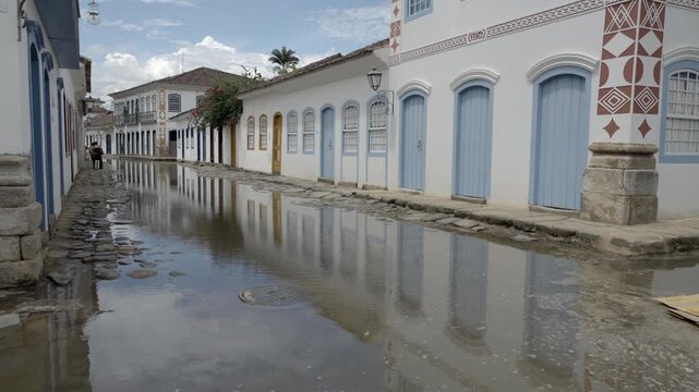 Street-level shot of Paraty&rsquo;s historic colonial streets, flooded with water. Captures the unique atmosphere of this UNESCO old town during seasonal flooding, surrounded by charming houses