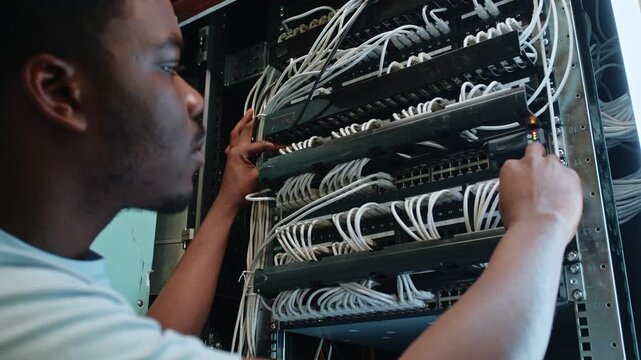 Man works on server rack in data center at night during maintenance and troubleshooting tasks
