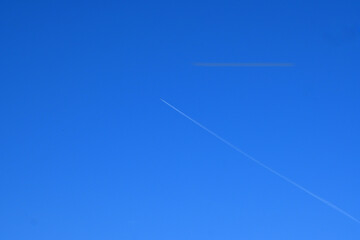 鮮やかな青空に描かれた一筋の飛行機雲