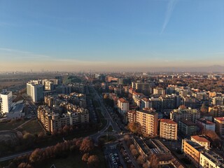 Aerial vista of an urban sprawl, buildings stand harmoniously under a cerulean canopy, depicting a dynamic blend of human construction with the vastness of the sky.