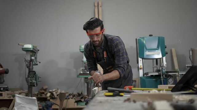 Carpenter is working at workshop. Small business and craft product.