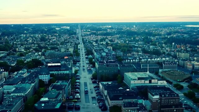Aerial view of a cityscape showing buildings, streets, and greenery. The urban environment features residential and commercial areas.