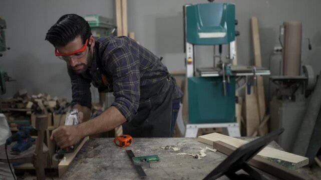 Carpenter is working at workshop. Small business and craft product.