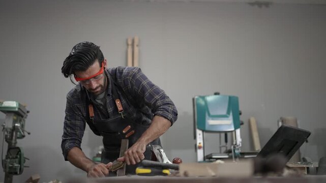 Carpenter is working at workshop. Small business and craft product.